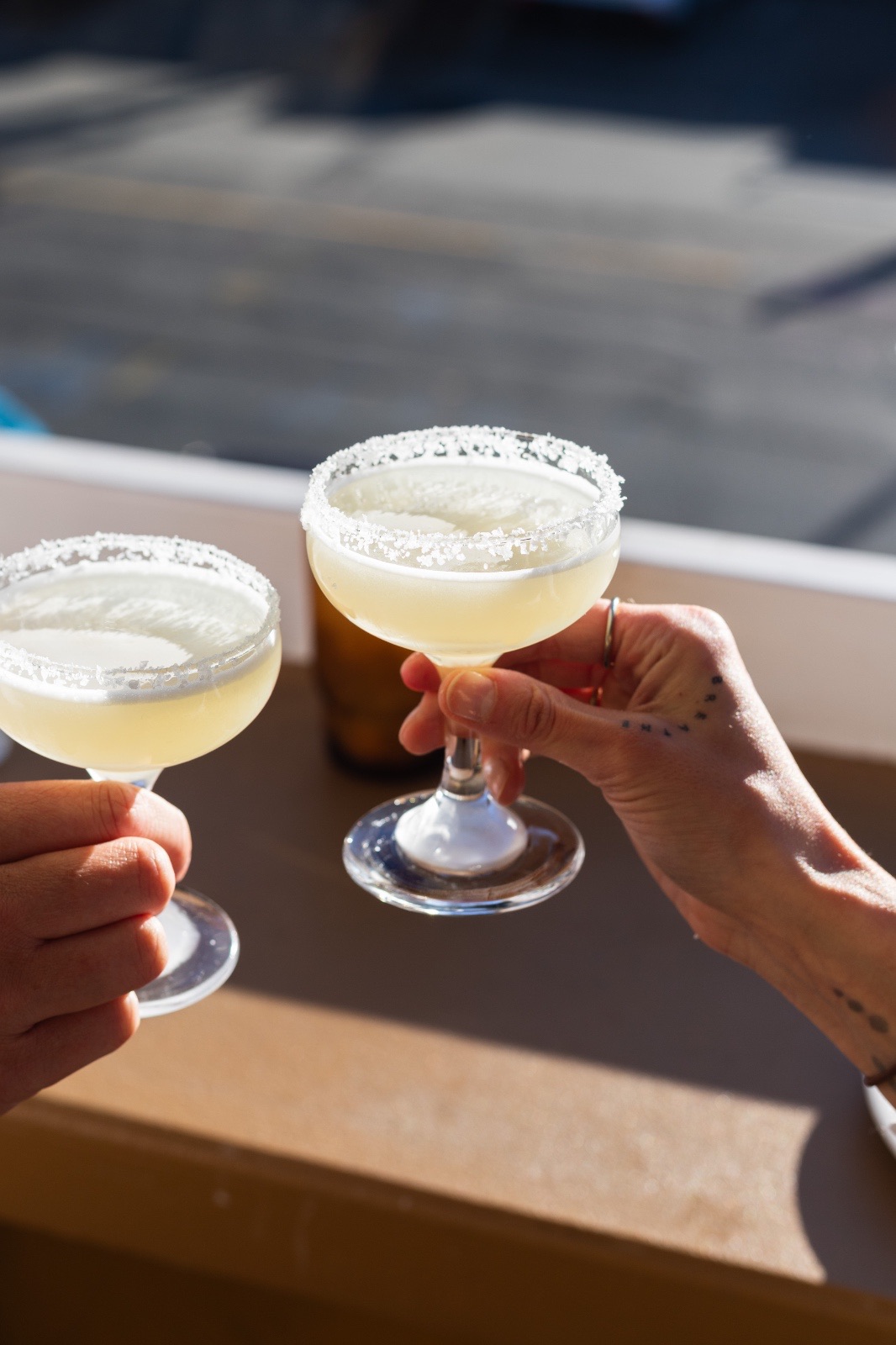 Two margaritas raised in a toast on the terrace at Elvina